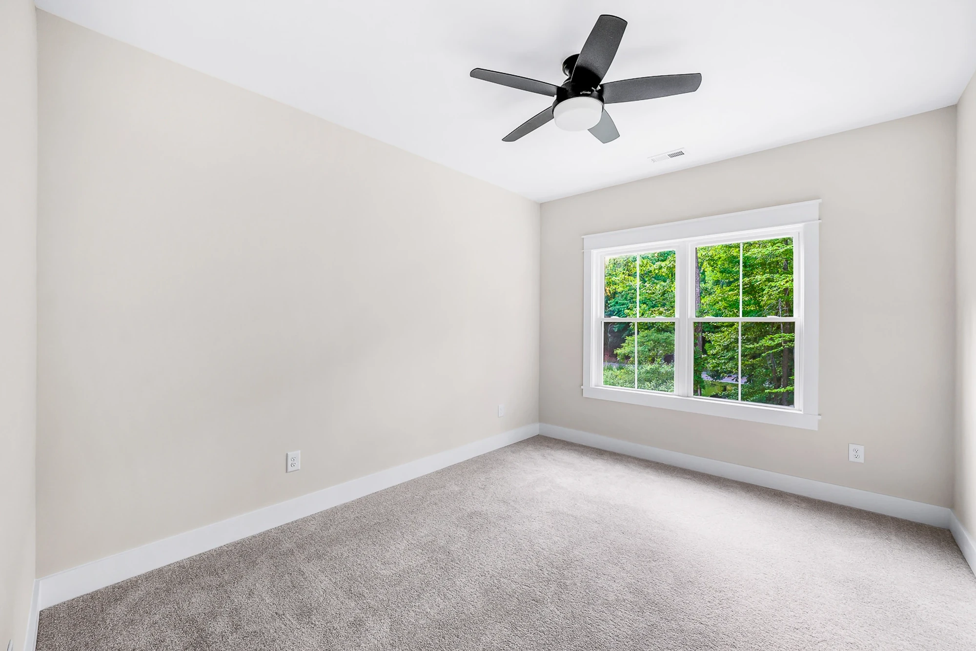 Bedroom with ceiling fan and wooded view