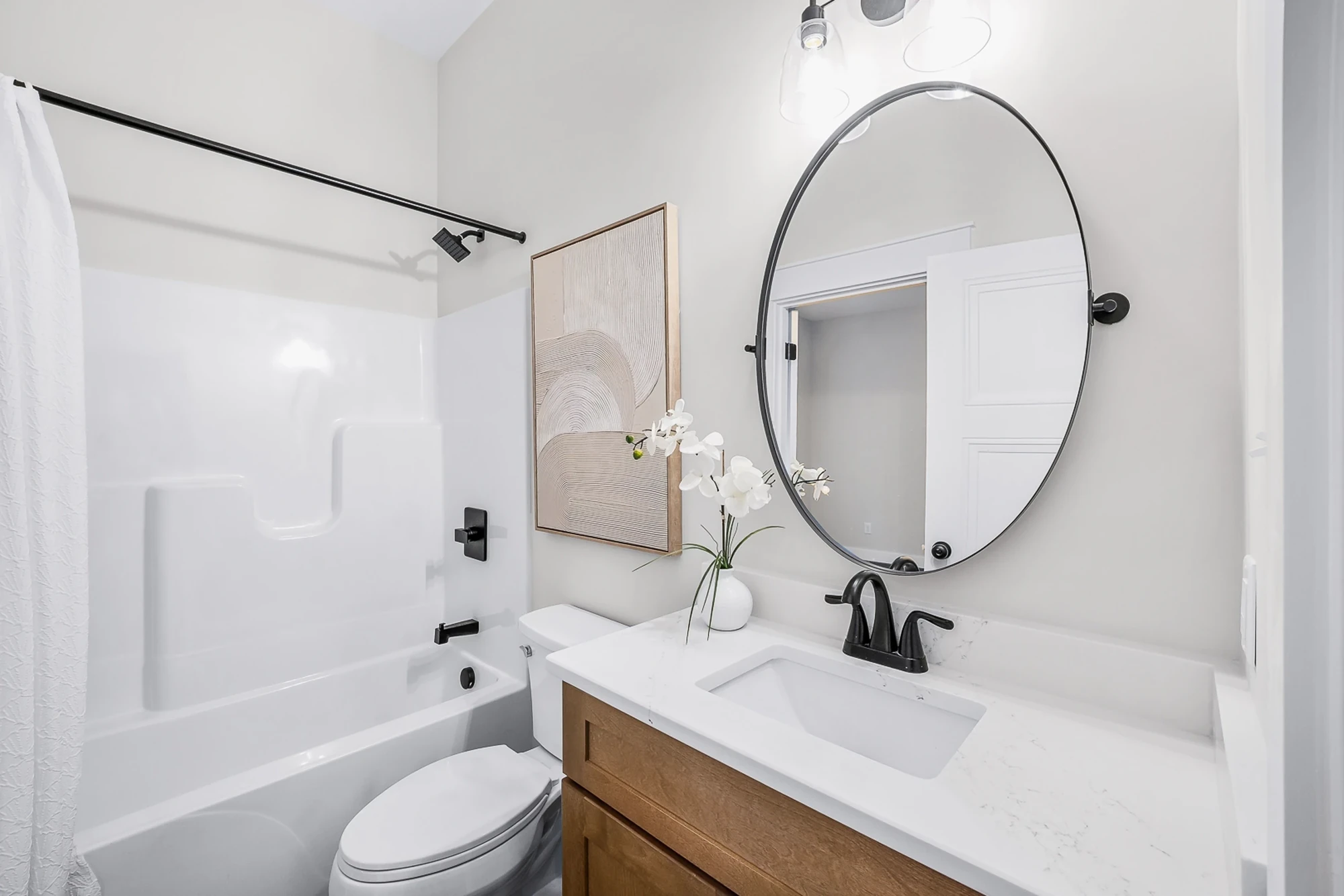 Bathroom with wood vanity and round mirror